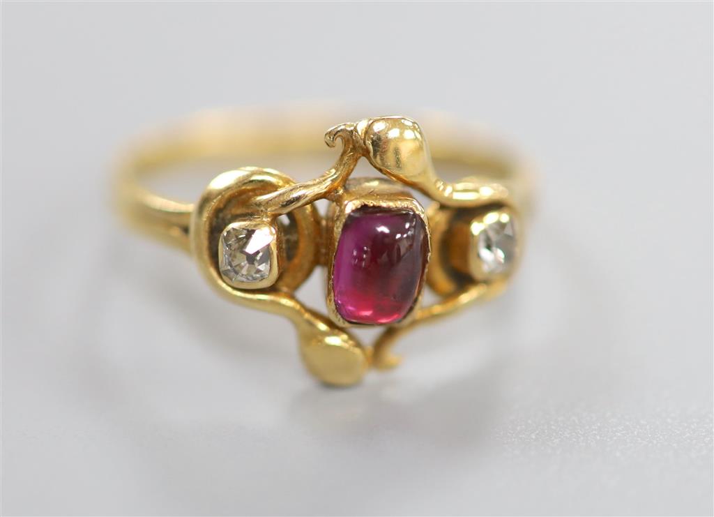 An early 20th century Arts & Crafts yellow metal, cabochon garnet and diamond set three stone ring, size O/P, gross 3 grams.